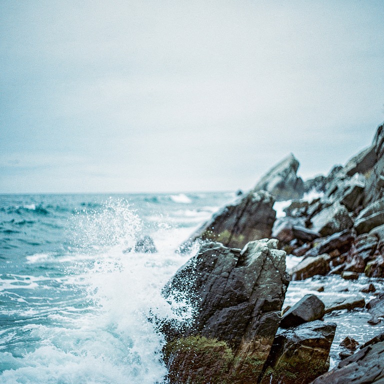 A rocky shoreline with sharp boulders and rough waves crashi... | ShopAyahuascaRetreats