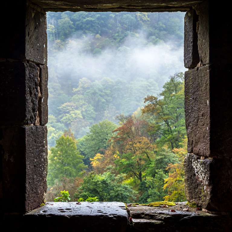Stone monastery window looking out onto a green forested val... | ShopAyahuascaRetreats