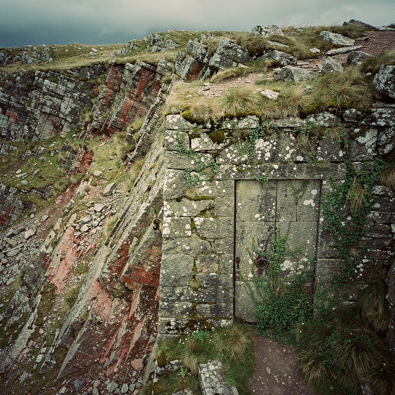 A massive stone door, covered in moss and lichen, appears lo... | ShopAyahuascaRetreats