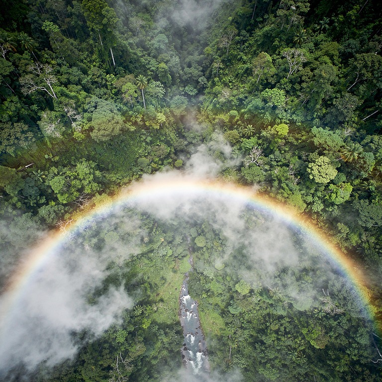 Rainbow arching over a misty rainforest valley after a storm | ShopAyahuascaRetreats